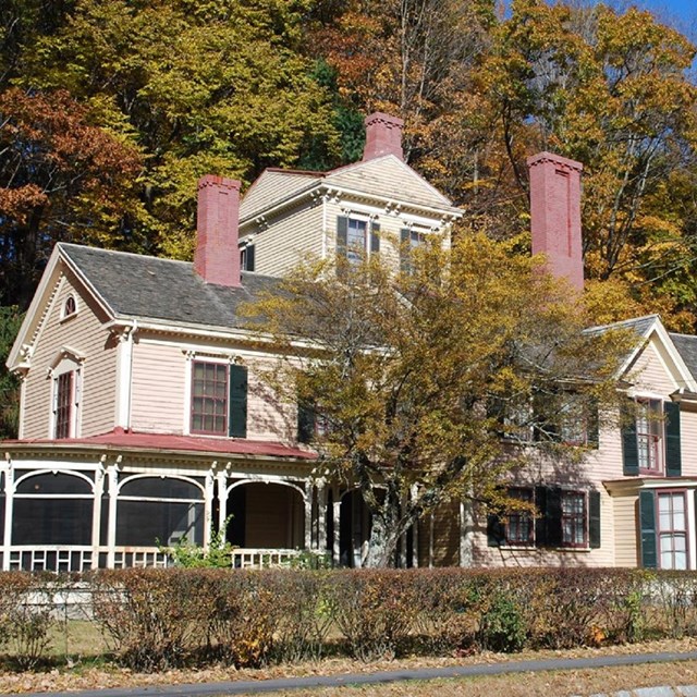 Large house with green shutters and brick chimneys