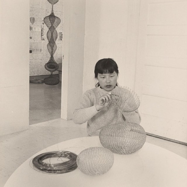 Asian American woman with wire sculpture
