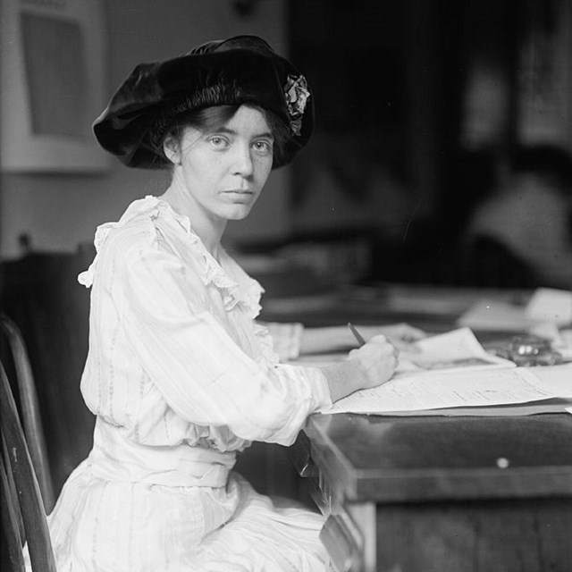Alice Paul standing next to equality flag with stars. Courtesy of the Library of Congress.  