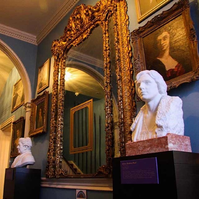 Interior of the entryway to the house with large mirror and busts. Courtesy National Woman's Party.