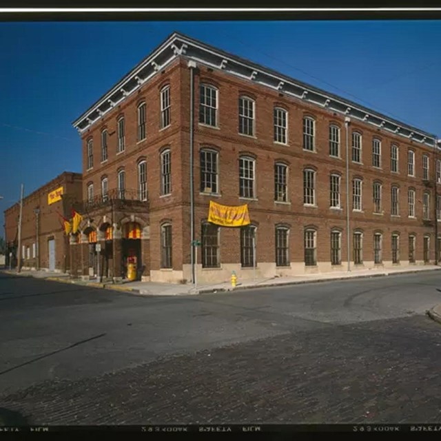 Exterior image of a brick building with yellow banner against blue sky.