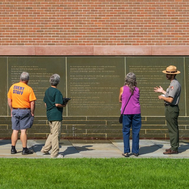 Visitors learning about Declaration of Sentiments at the Waterwall in Declaration Park.