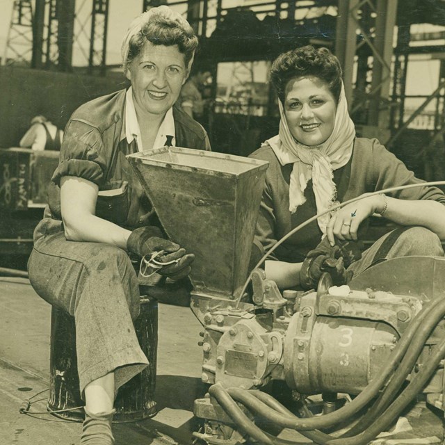 Two women in factory; black and white photo