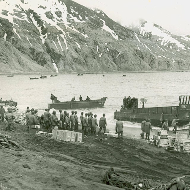 boats pull ashore, mountain in background, B&W photo