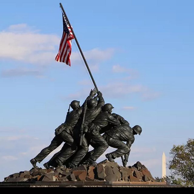 statue of 6 men raising planting a flag pole with an american flag