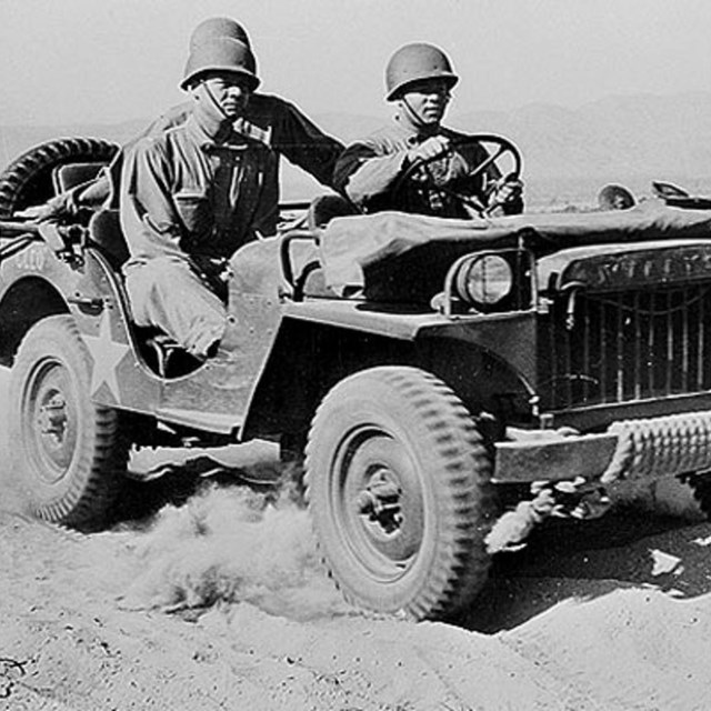 three men in uniform in wwii military jeep