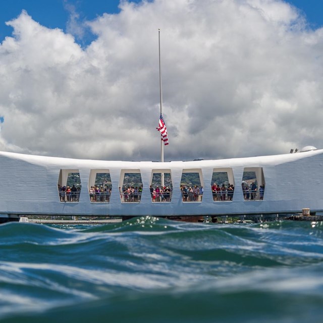 white bow shaped memorial seen from water level in the ocean
