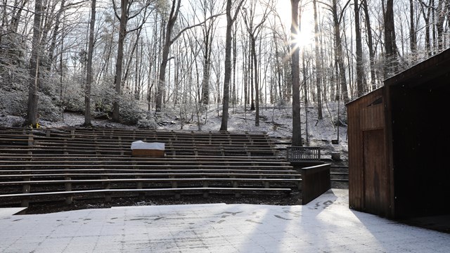 An empty theater in the woods after snowfall.