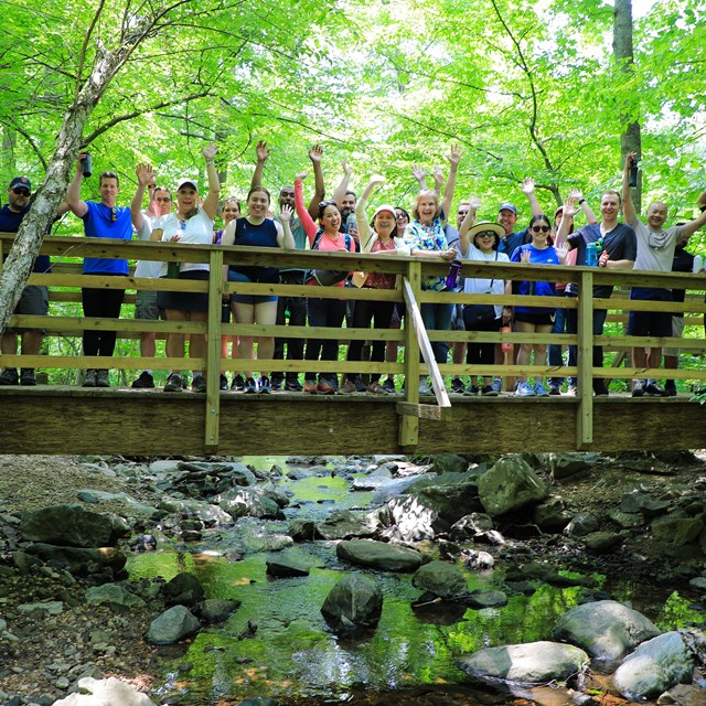 A group of hikers on a footbridge.