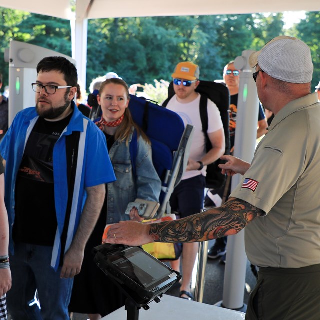 Staff members inspecting patrons cooler and bags prior to entrance at Filene Center Main Gate