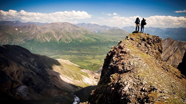 Two hikers overlooking a vast swath of land.