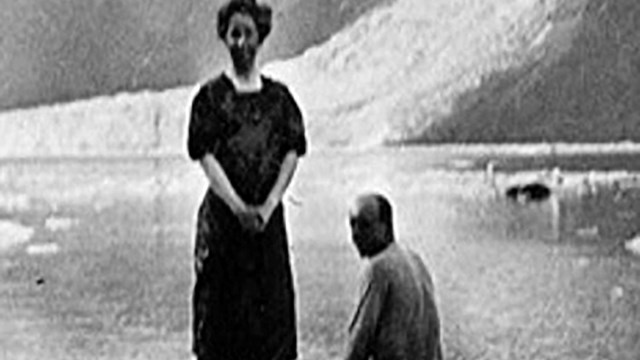 Dora Keen standing on a piece of ice next to her husband. 