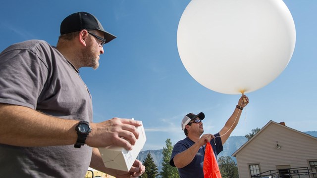 Two people send up a weather balloon