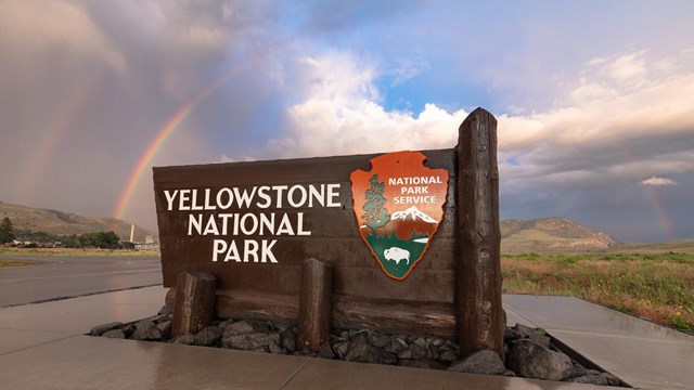 Yellowstone National Park entrance sign with double rainbow