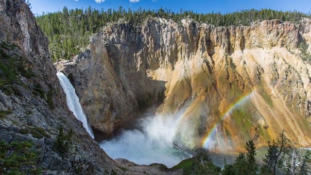 a rainbow near a waterfall
