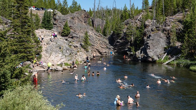 Visitors enjoying the thermally-heated waters at the Firehole Canyon Swim Area