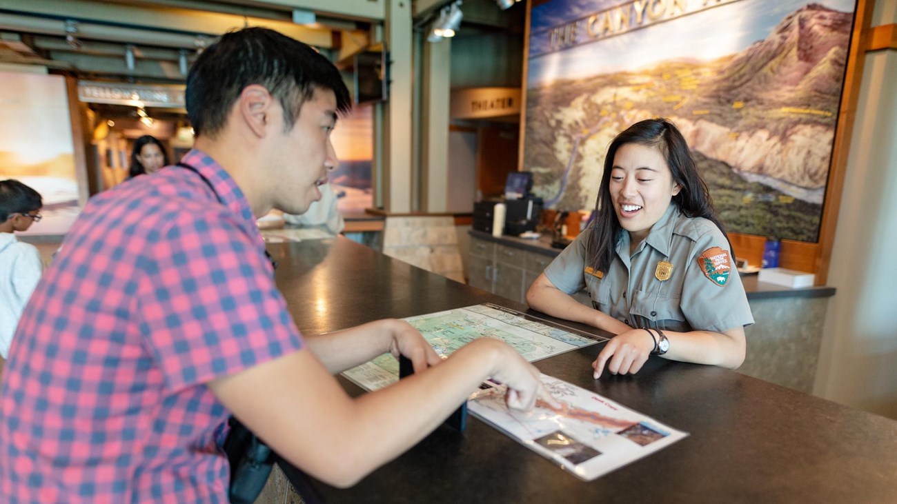 Ranger giving information to a visitor at a desk