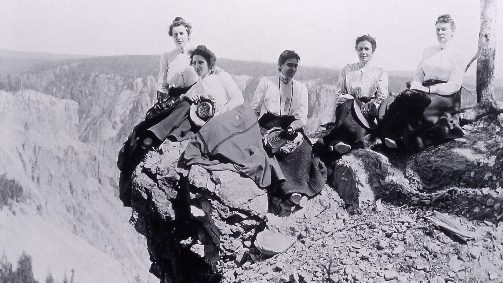 Historic photograph of employees sitting on the rim of a canyon