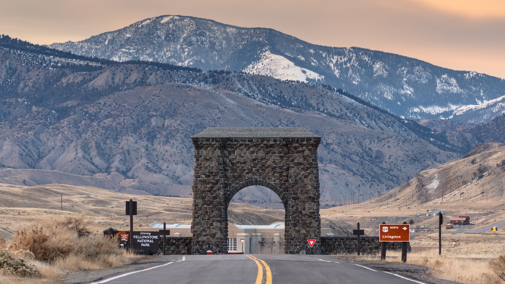 A brick arch with mountains with a mountainous background
