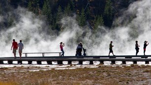 A visitor used a mobility aid to travel along the boardwalks at Midway Geyser Basin.