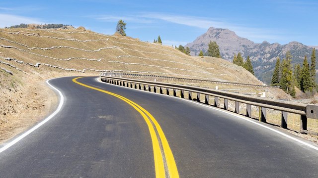 A newly constructed road winds along a hillside