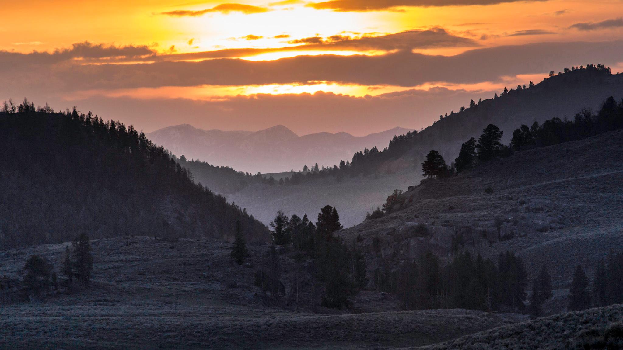 orange sunset over silhouetted mountains