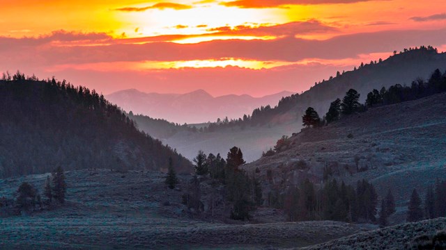 orange sunset over silhouetted mountains