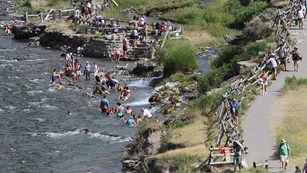 Visitors enjoying the thermally-heated waters where the Boiling River enters the Gardiner River.