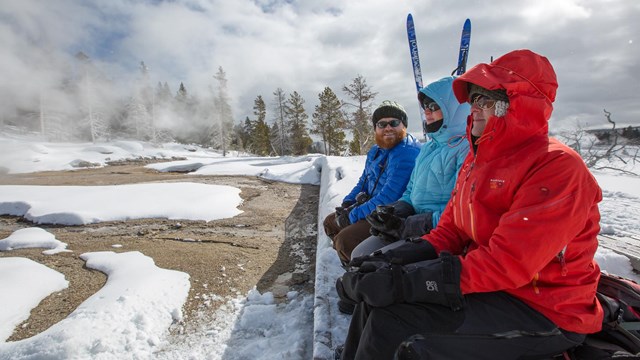 People bundled up while waiting for an eruption of a geyser.
