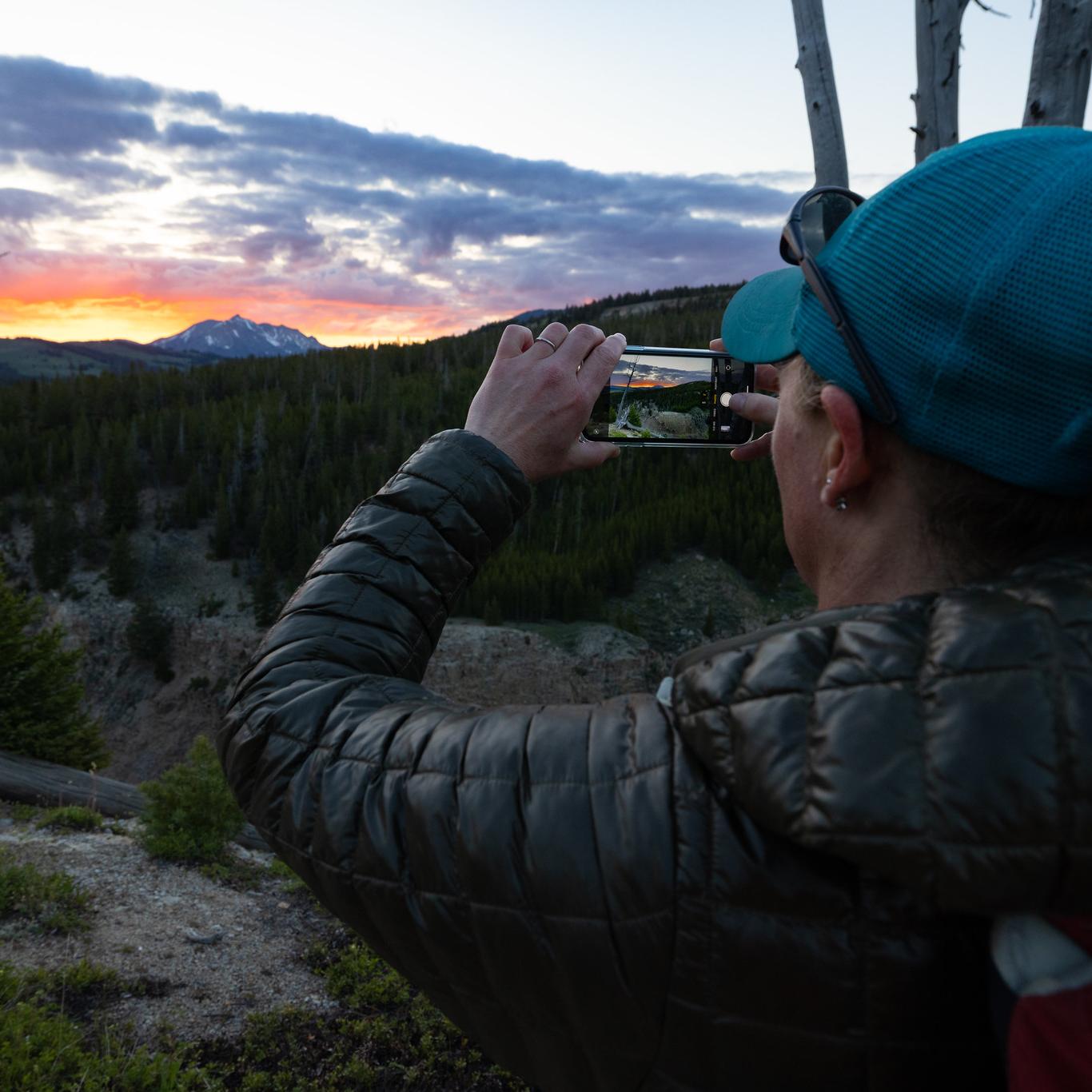 Taking a photo of a sunset over a mountain