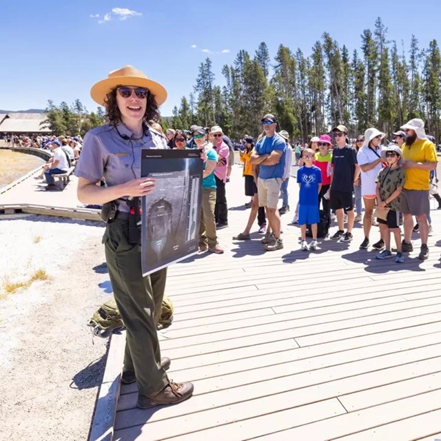 several visitors listening to a park ranger give a program