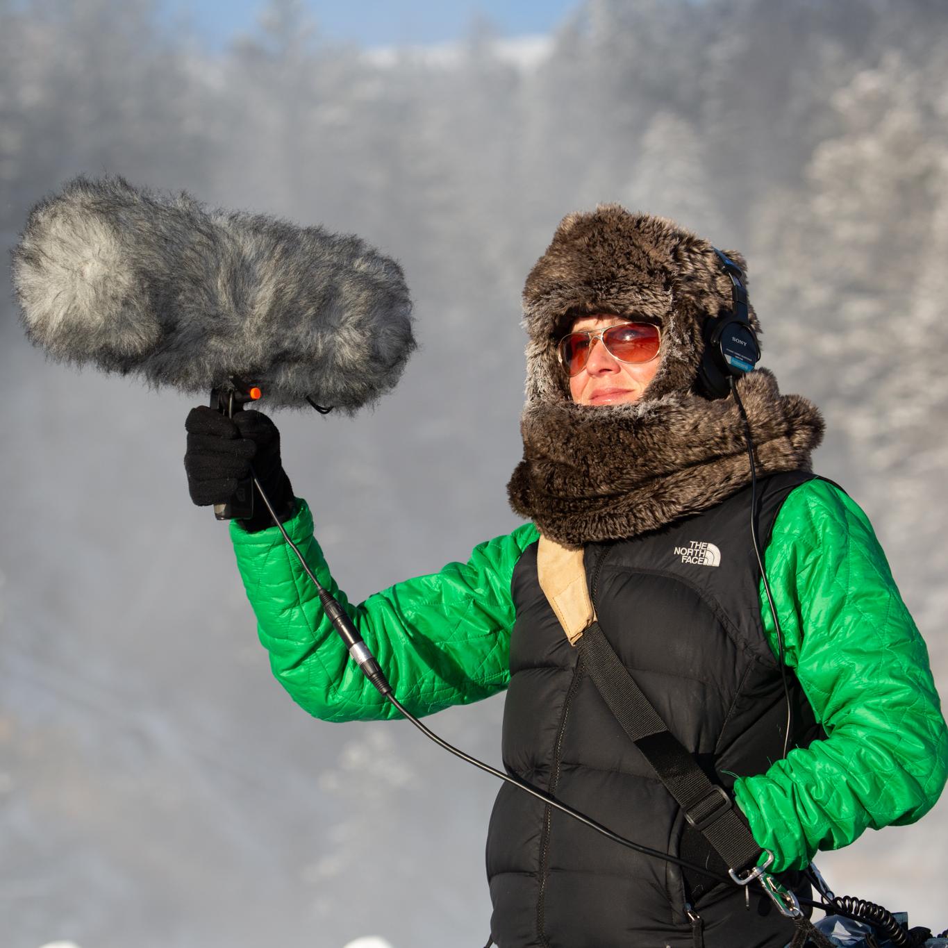 A person holds up a large microphone