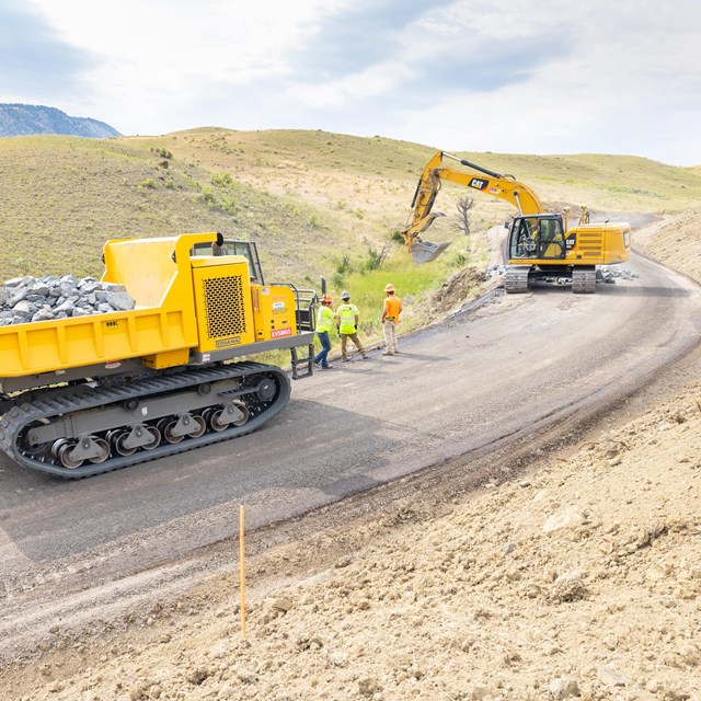 large construction vehicles on a newly paved roadway