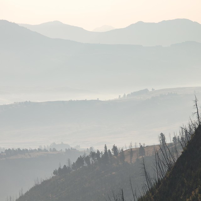 Smoke obscures the valleys and mountains in a wilderness landscape