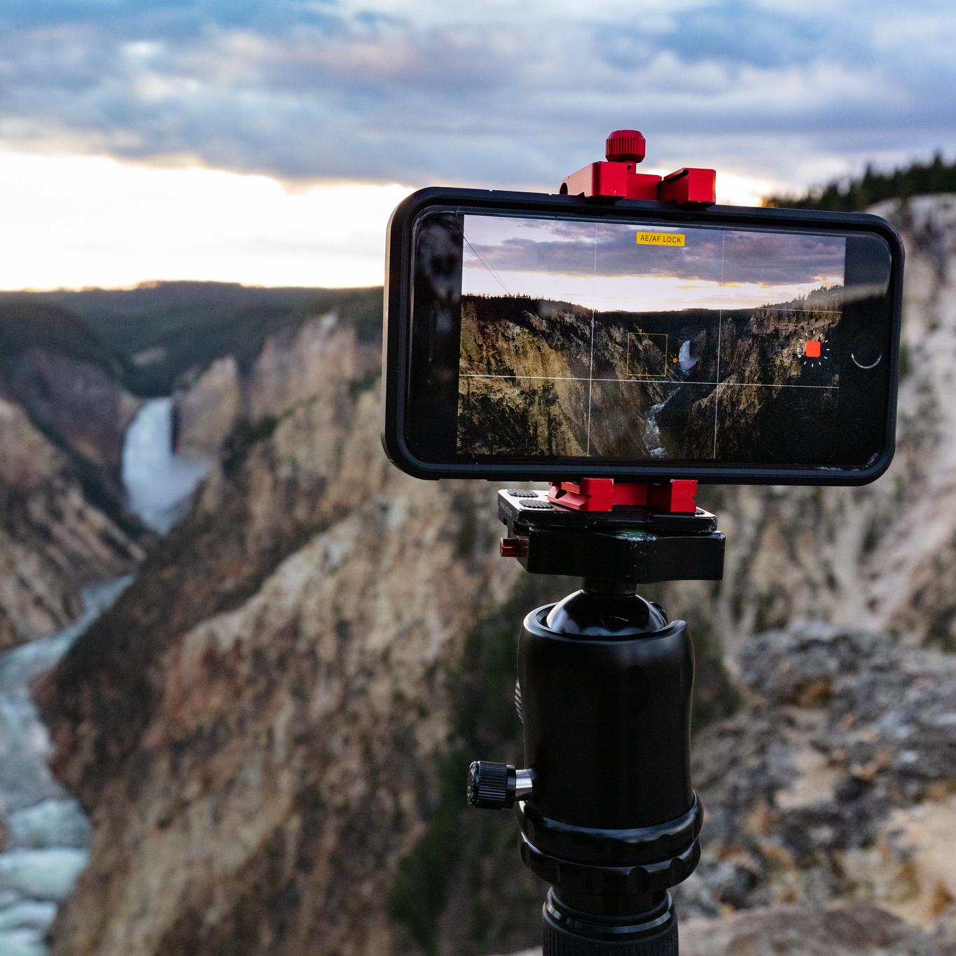 Photo of a camera taking video of a canyon at sunset.