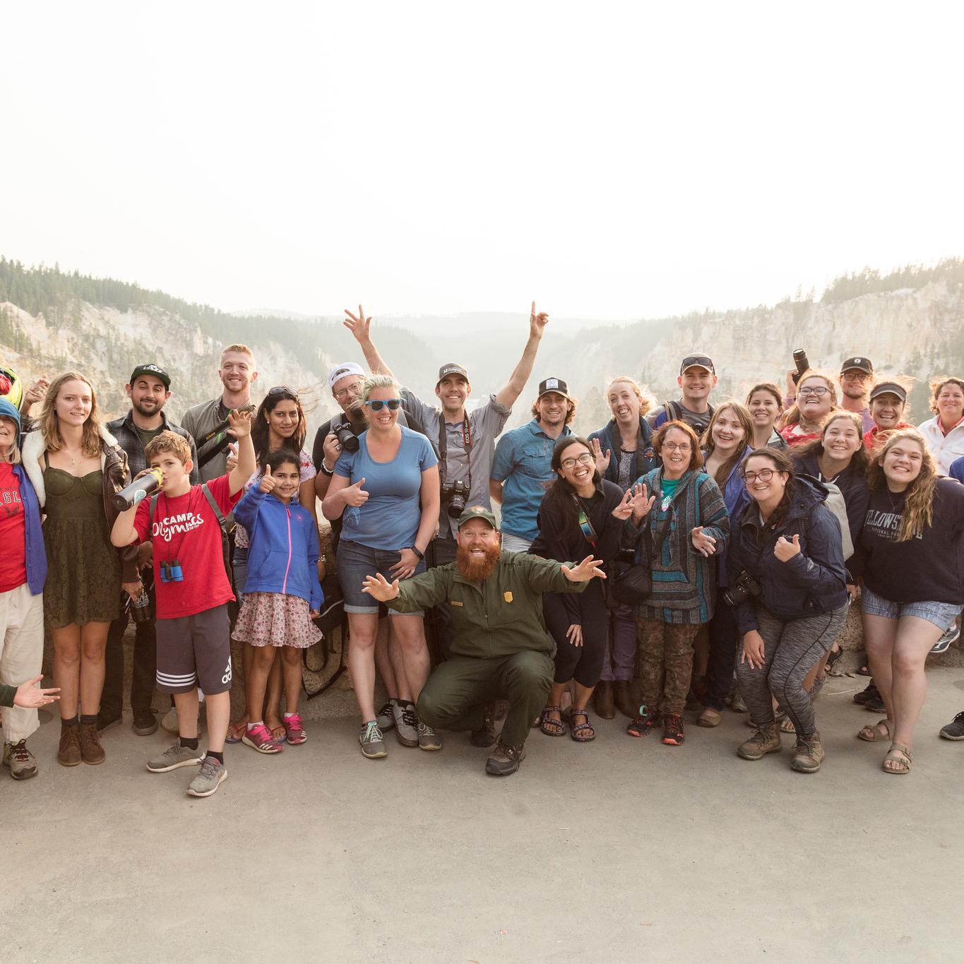 Group of people taking a photo with a ranger at sunset.