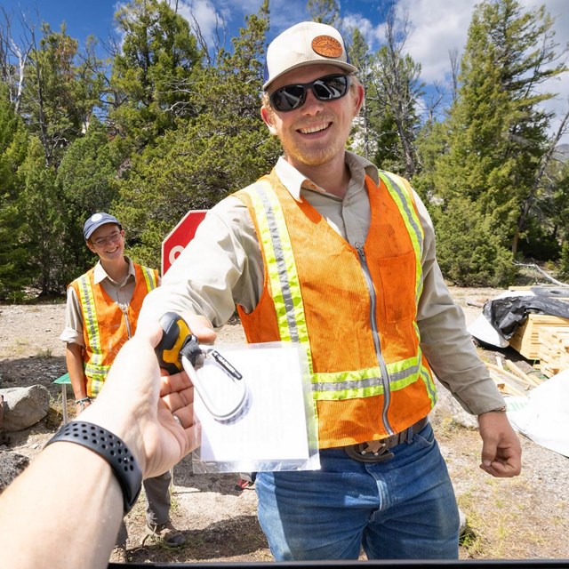 Handing a GPS unit to a person in a vehicle