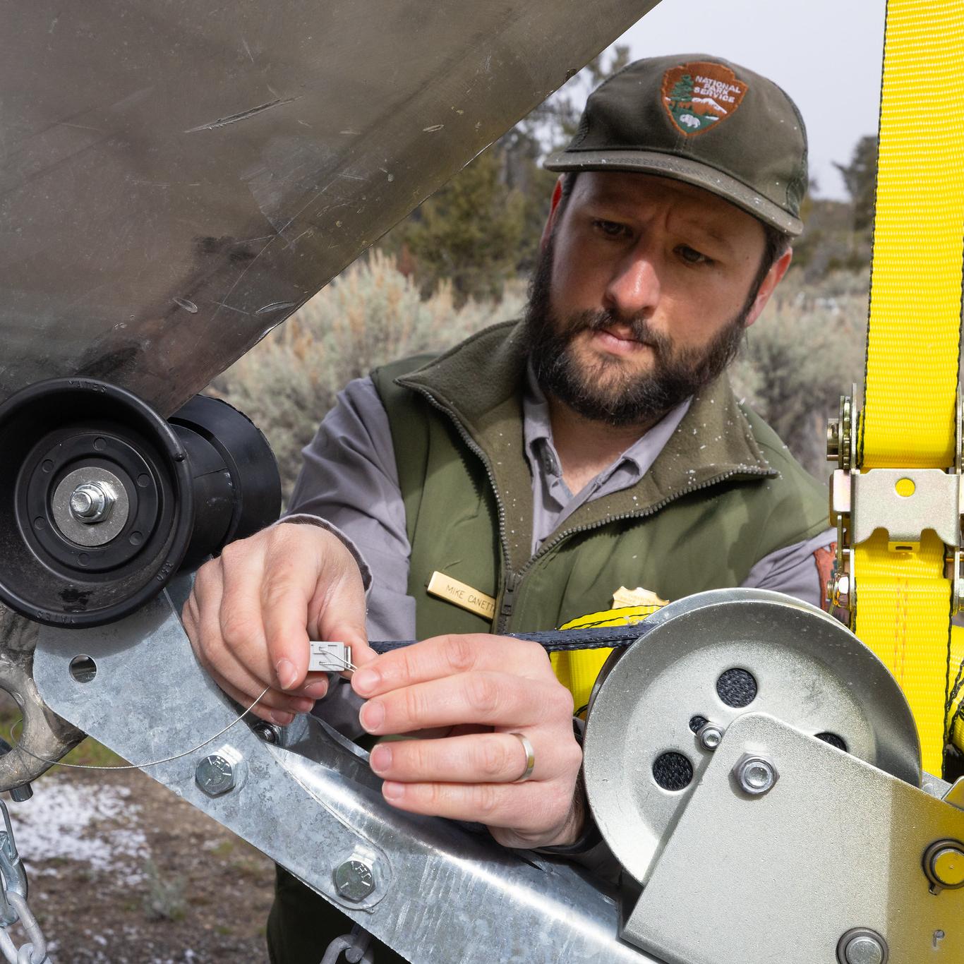 a park ranger installing a seal on a boat