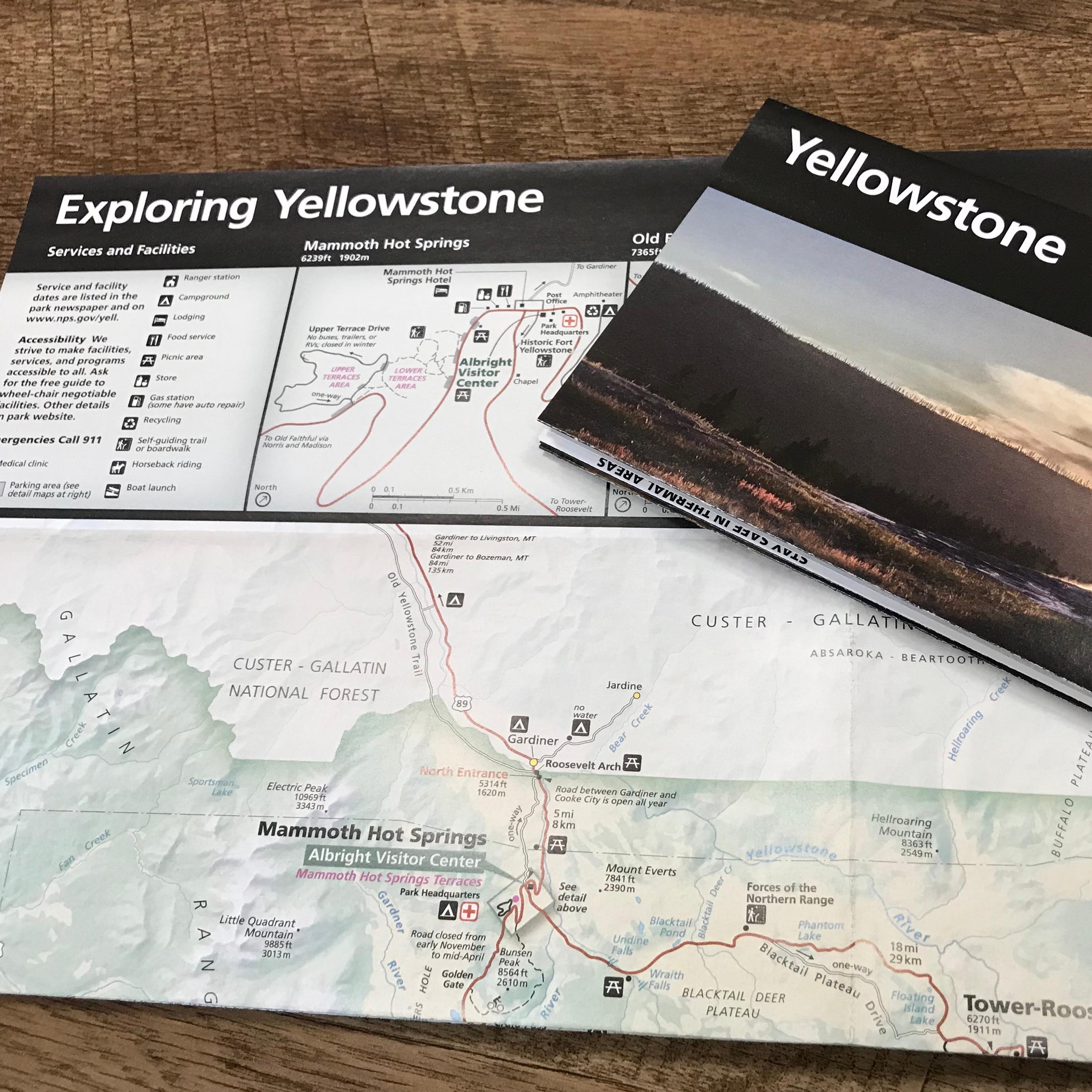 A brochure with the word Yellowstone sits on top of another unfolded brochure.