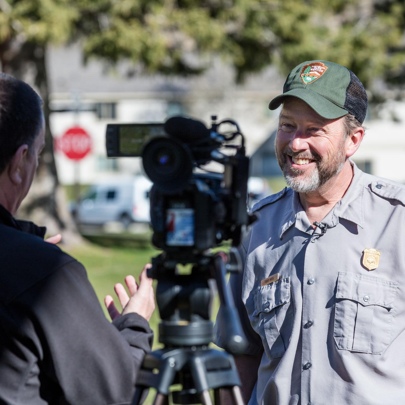 A park employee stands in front of a camera and answers questions.