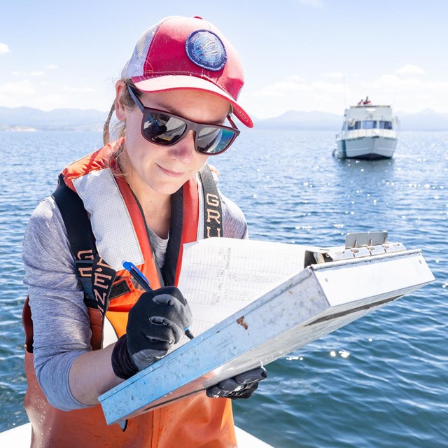 A person fills out a form on a clipboard.