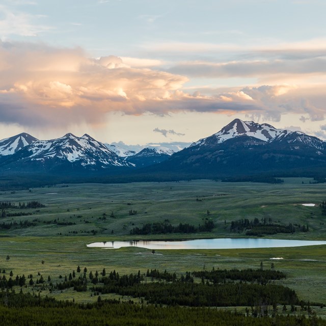 a wide view of a mountain range and small lake after a rainstorm