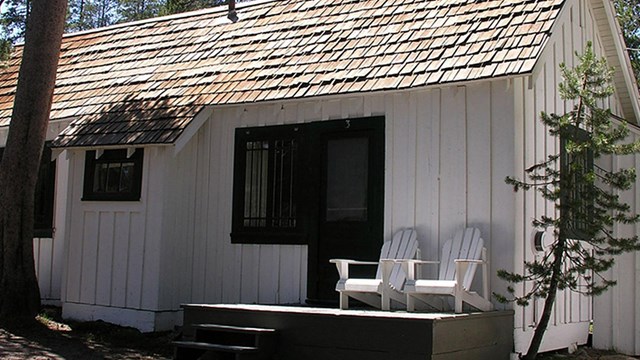A white-painted cabin with dark shutters at White Wolf Lodge.
