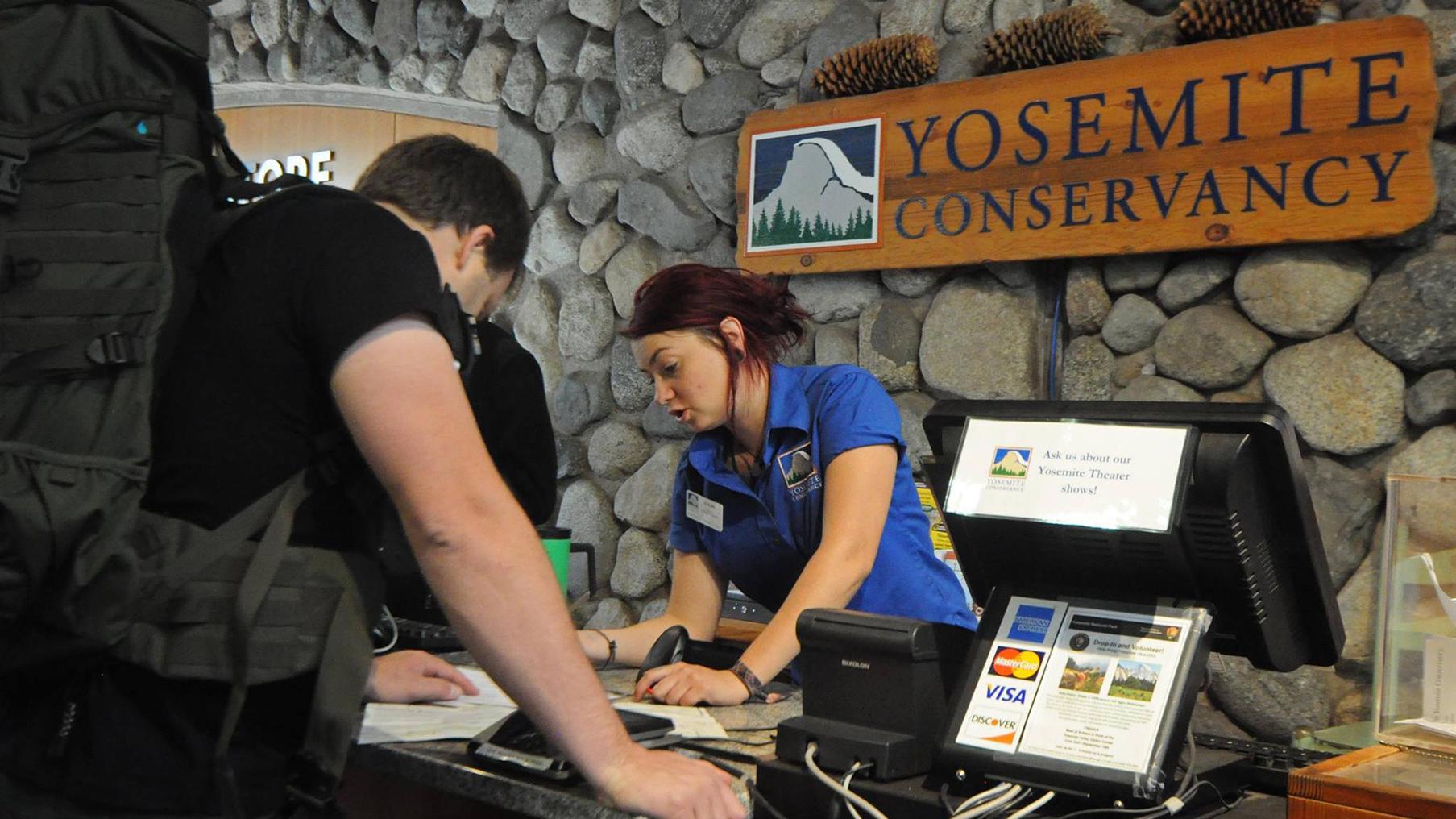 Yosemite Conservancy bookstore employee at the sales desk in Yosemite Valley at the visitor center.
