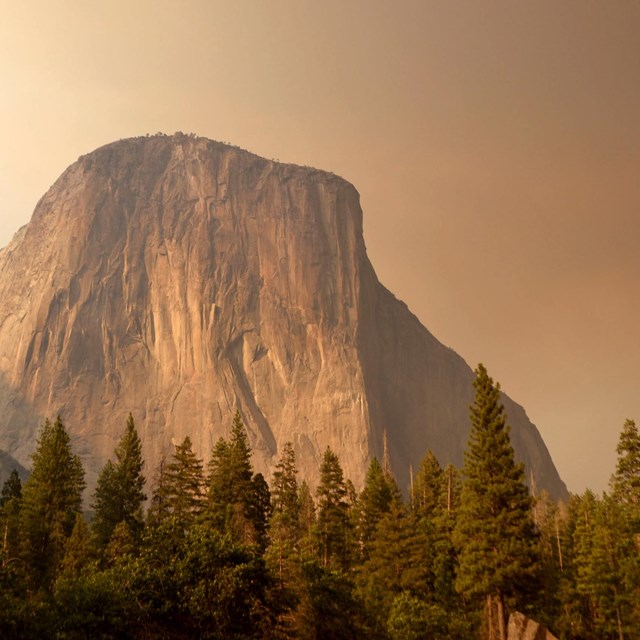 El Capitan rises through smoke from a wildfire