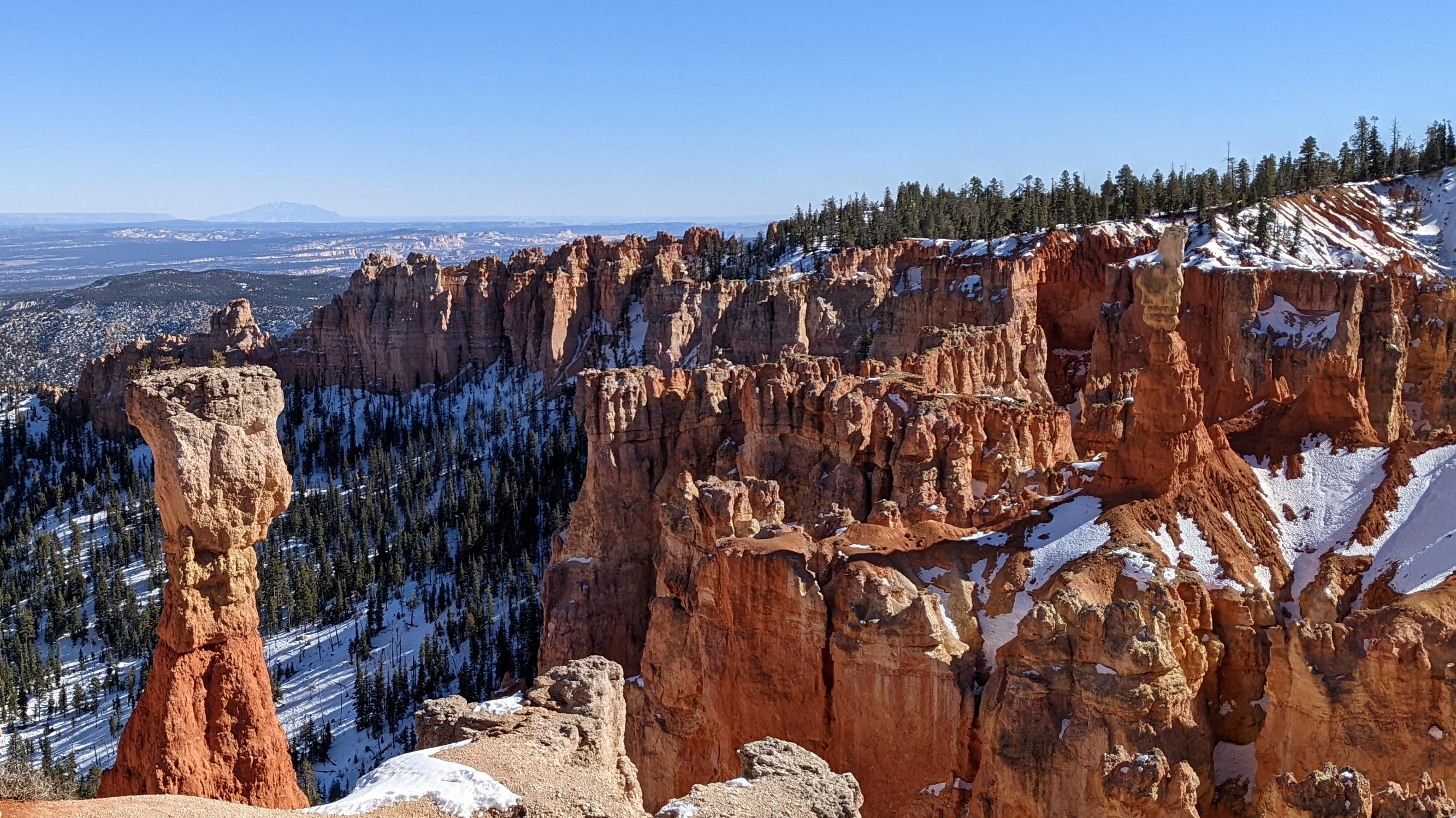 Red rocks stand tall in front of a blue sky