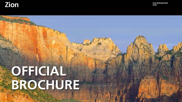 Blue sky over sandstone mountains with the text "Official Brochure"