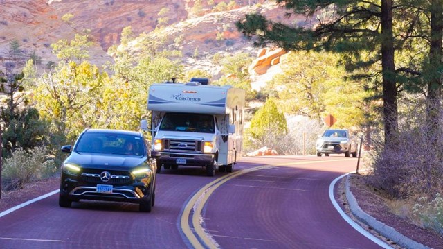 A recreational vehicle drives between two cars on the Zion-Mt. Carmel Highway.
