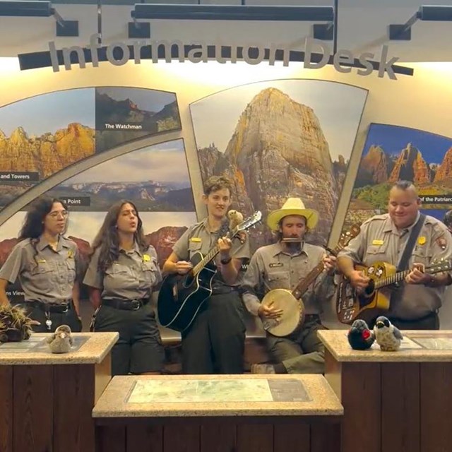 A band of five rangers perform behind the Visitor Center front desk.