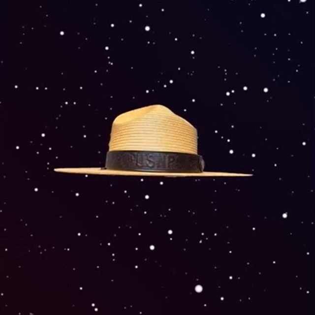 A park ranger hat floats through deep space.